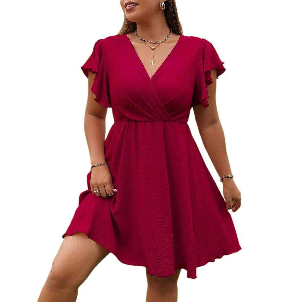 A woman wearing a short magenta wrap-style dress with flutter sleeves and a V-neckline, shown against a plain white background.