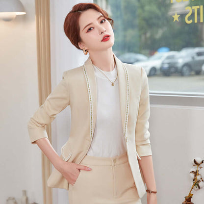 Woman wearing a beige blazer and skirt set indoors with blurred background