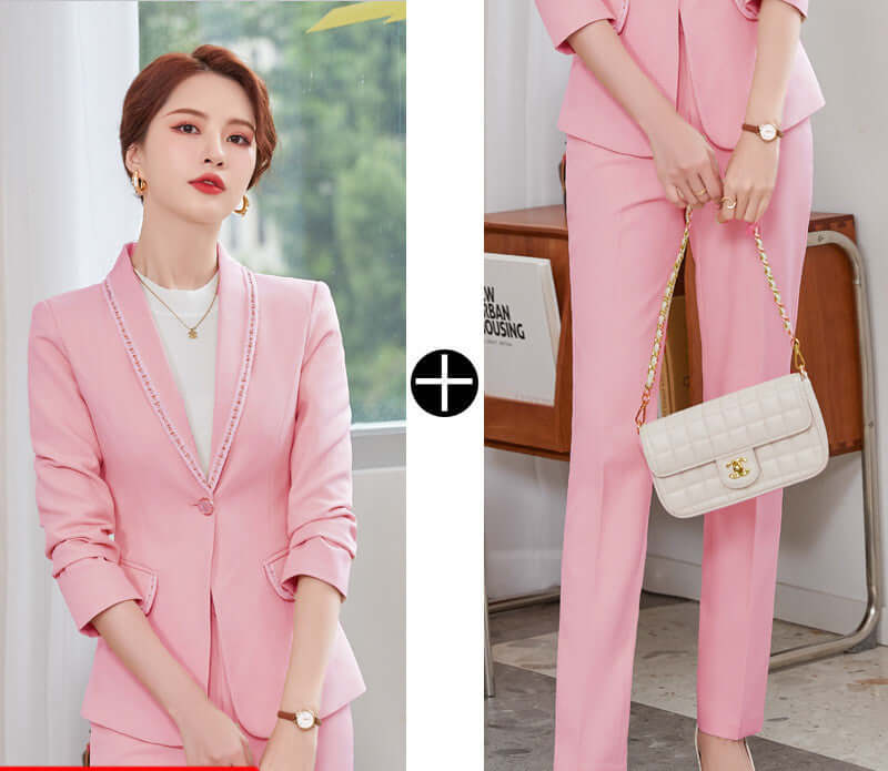 Woman wearing a pink suit with a white handbag indoors.