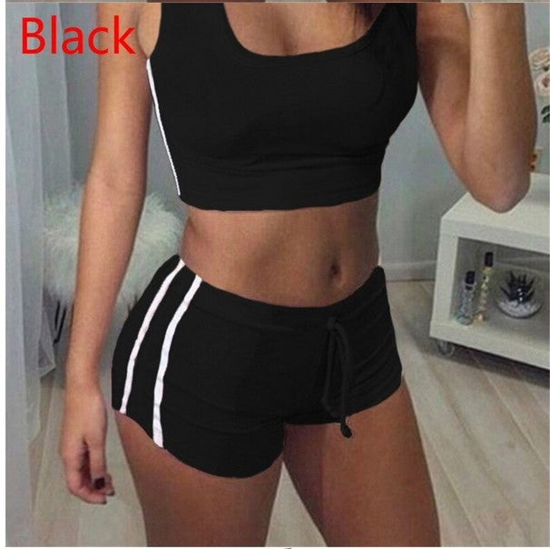 Woman wearing black athletic shorts with white stripes and a black sports bra.