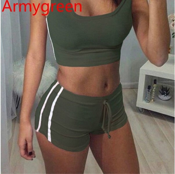 Woman wearing an army green sports outfit with a white stripe in a room.