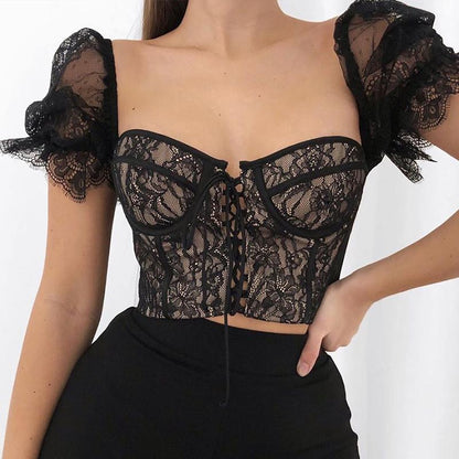 Black lace top worn by a model on a white background
