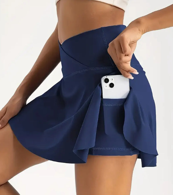 Woman wearing a navy blue skirt with a white phone in the pocket on a light gray background